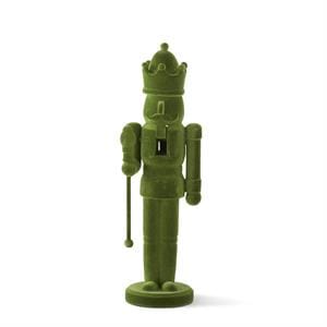 Green plush nutcracker toy on a white background