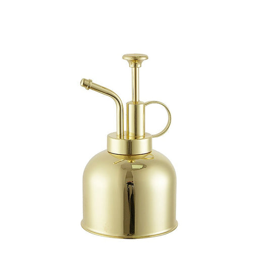Gold-colored metal spray bottle on a white background