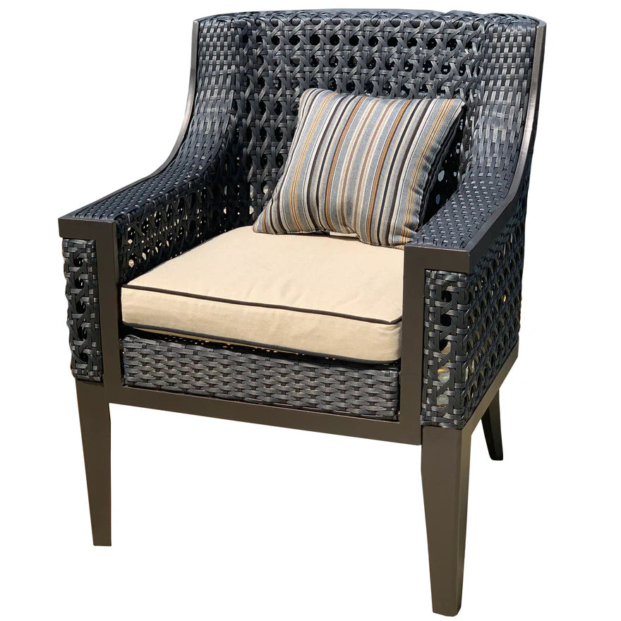 A dark woven outdoor armchair with a beige seat cushion and a striped accent pillow, shown on a plain white background.