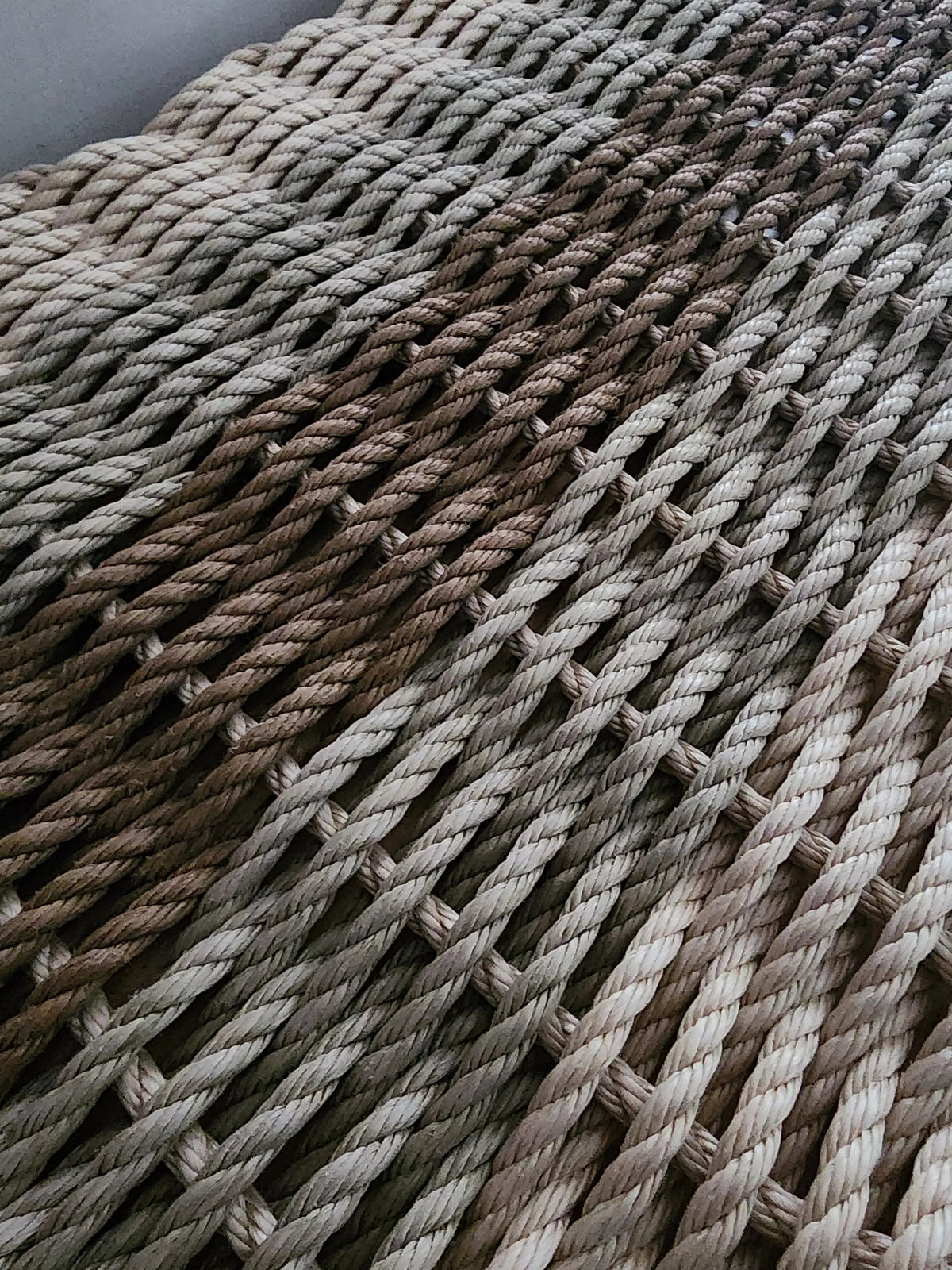 Close-up of woven rope mat with natural color gradient on a dark background