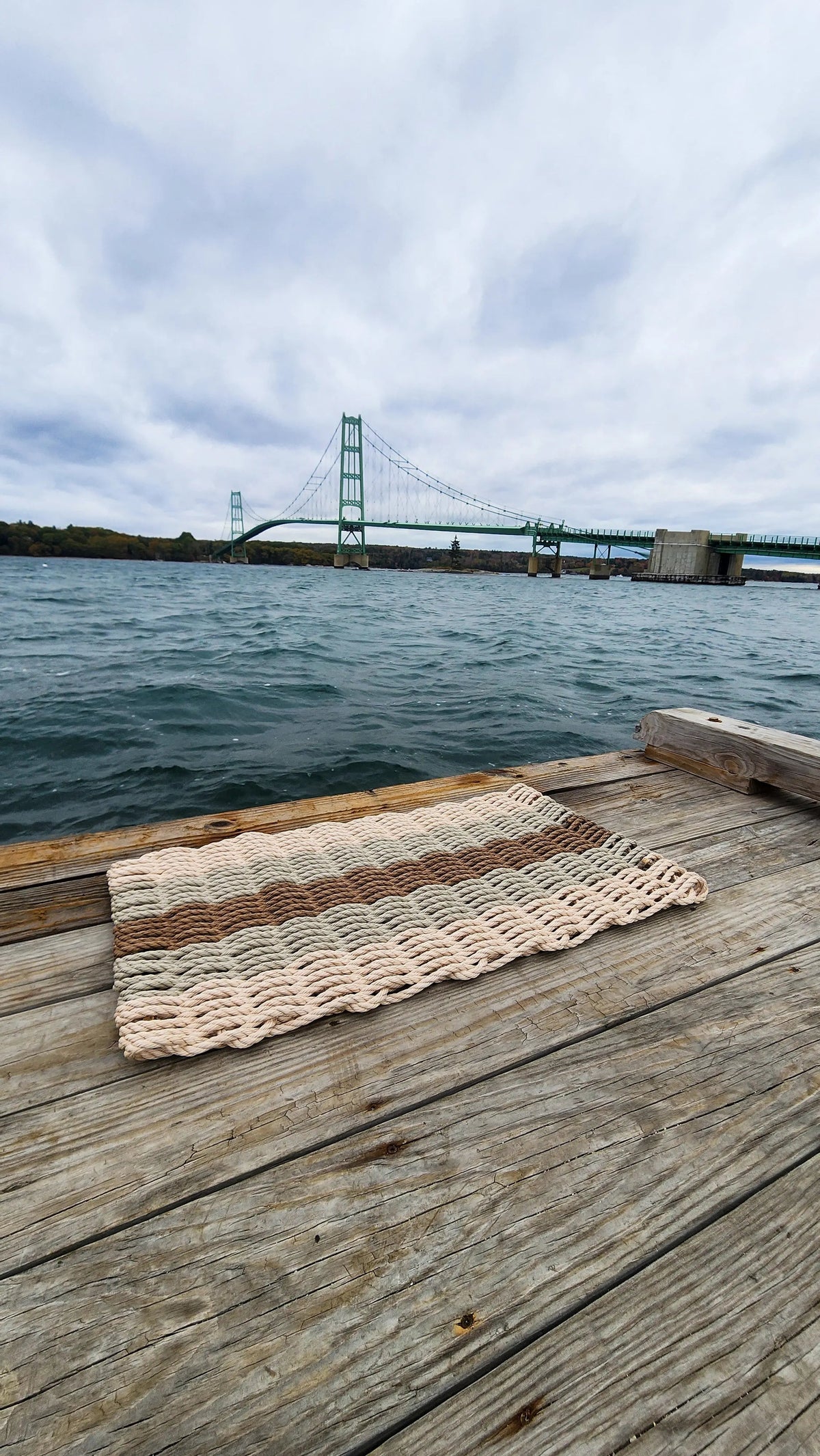 Textile on a wooden dock with a bridge and water in the background