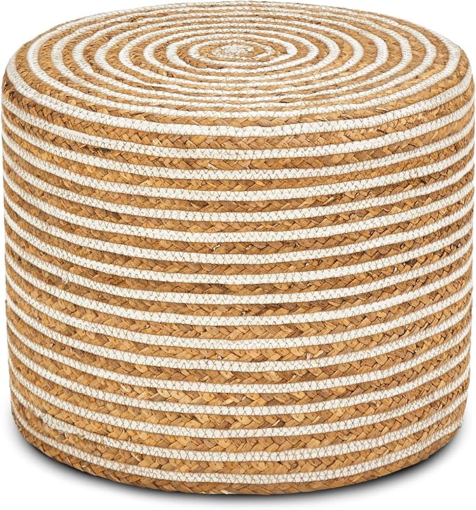 A round woven pouf ottoman made of natural tan seagrass with horizontal white rope stripes, shown on a clean white background.