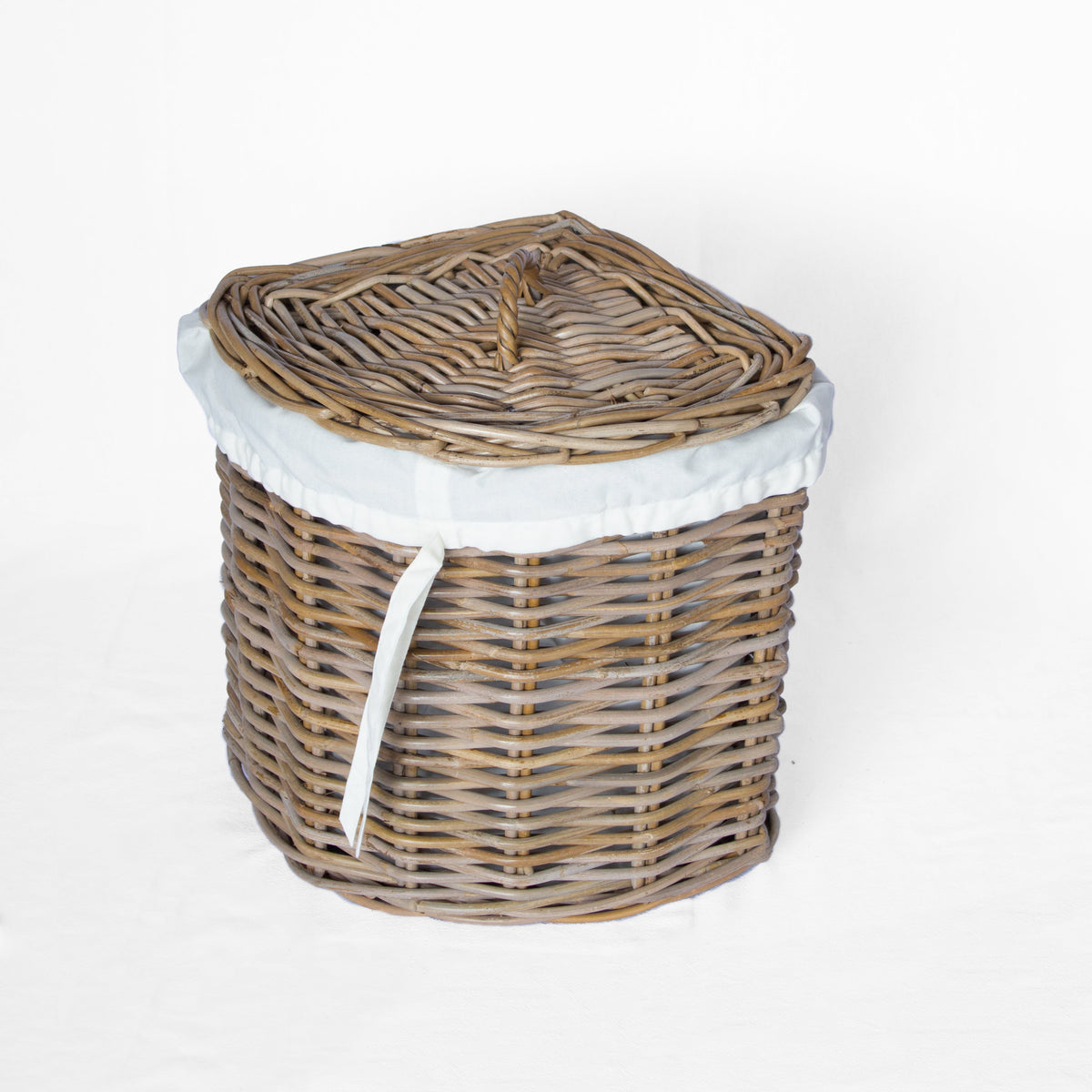 A round woven wicker basket with a matching lid, lined with a white fabric inner bag and tied with a white ribbon, shown on a plain white background.