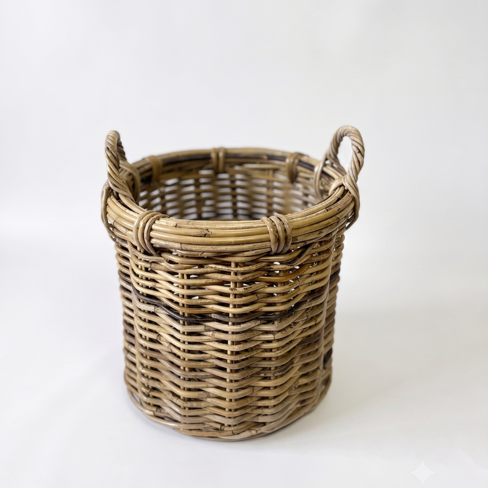 A natural woven wicker basket with two loop handles, shown on a plain white studio background.