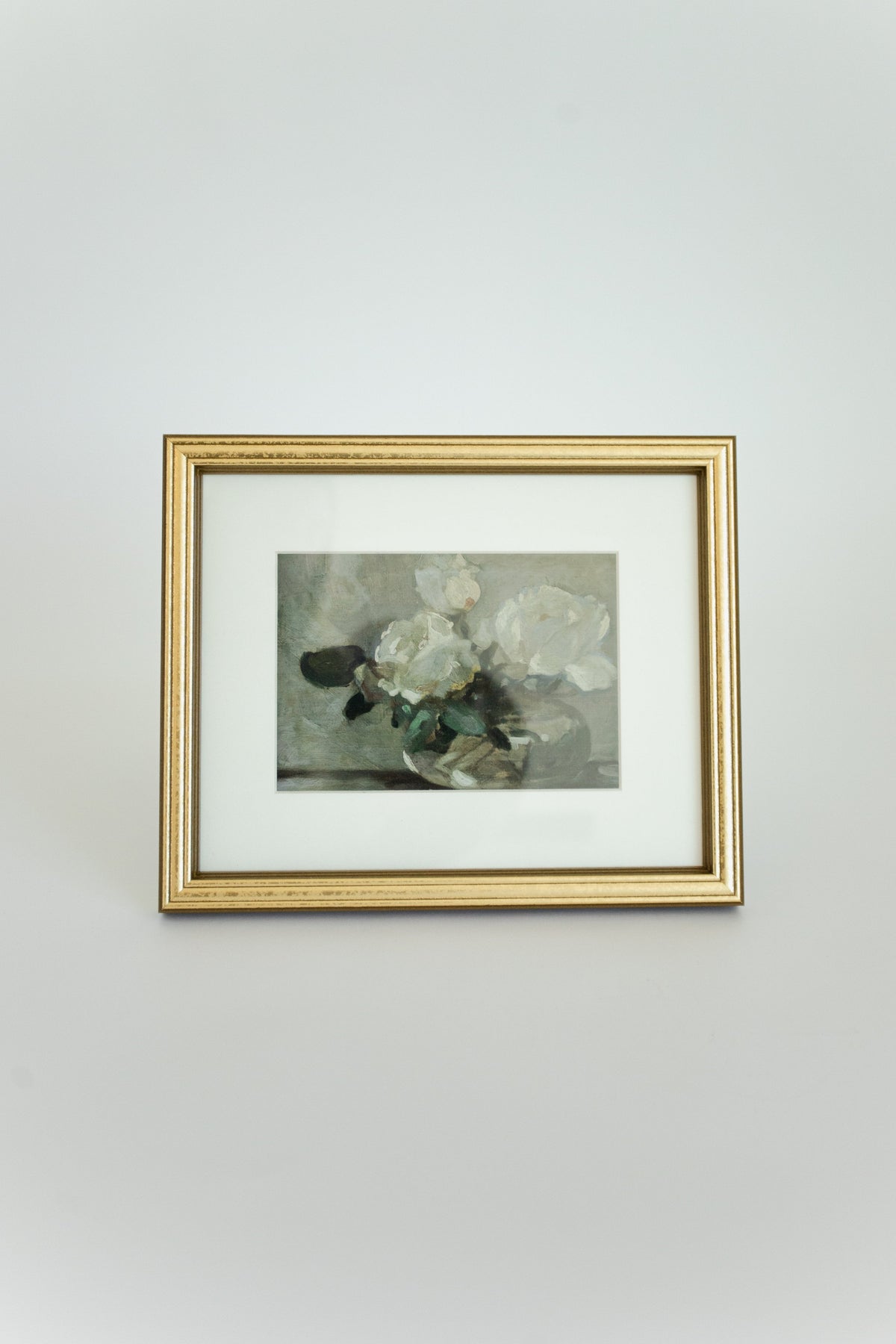 Framed artwork with floral design on a light gray wall