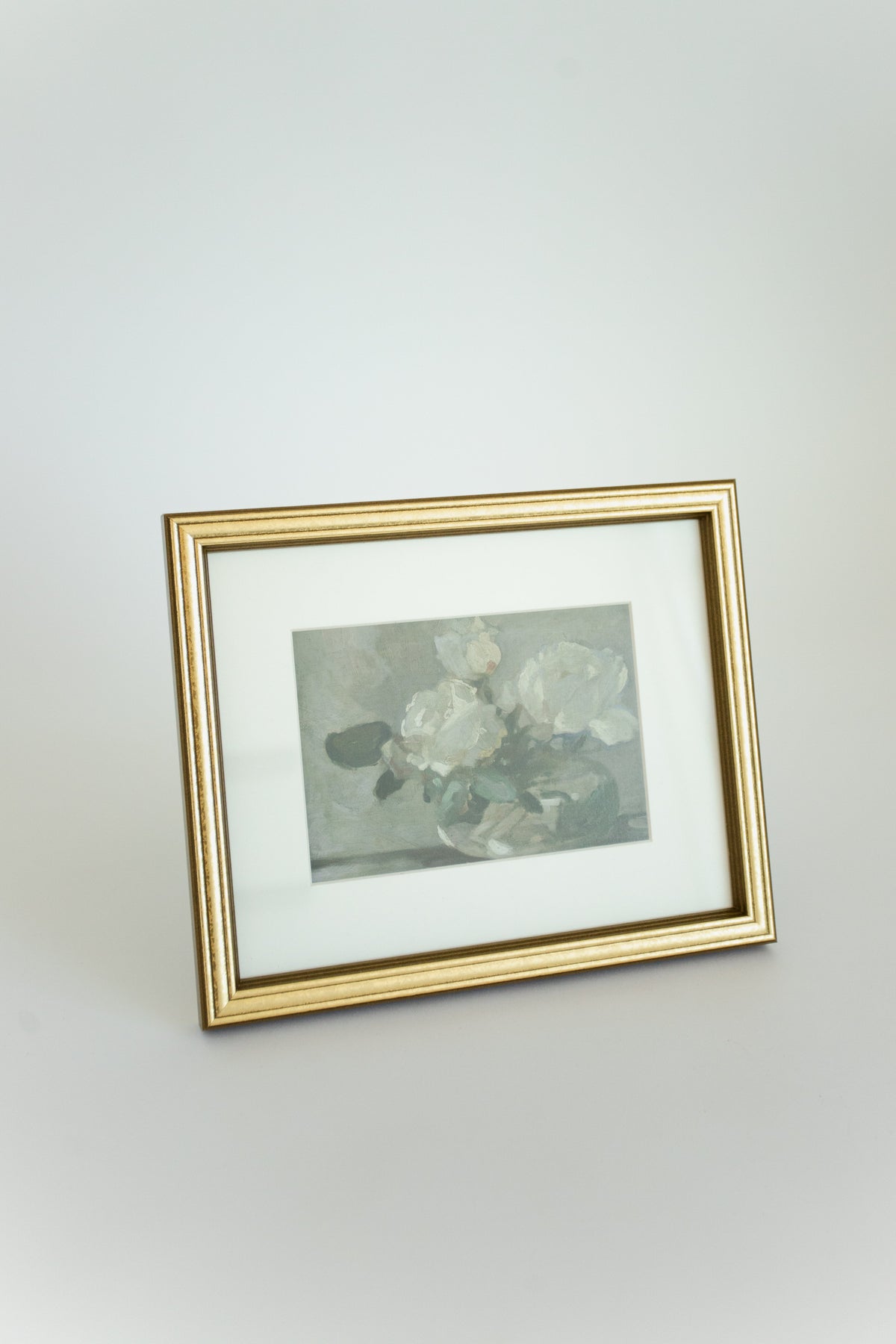 Framed artwork with floral design on a plain wall