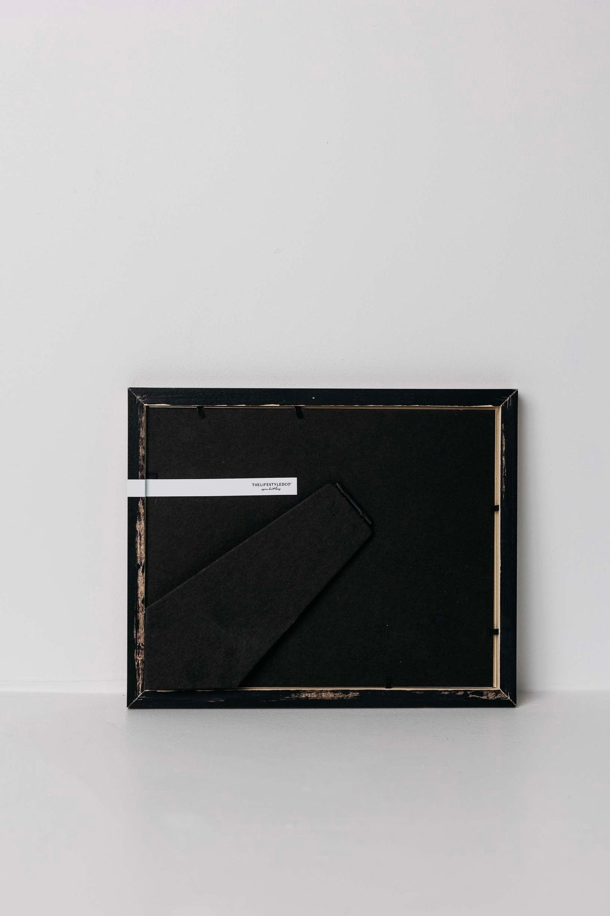 Black rectangular frame with a black sheet of paper inside on a white background