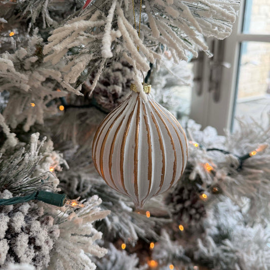 Decorative Christmas ornament on a frosted tree with lights