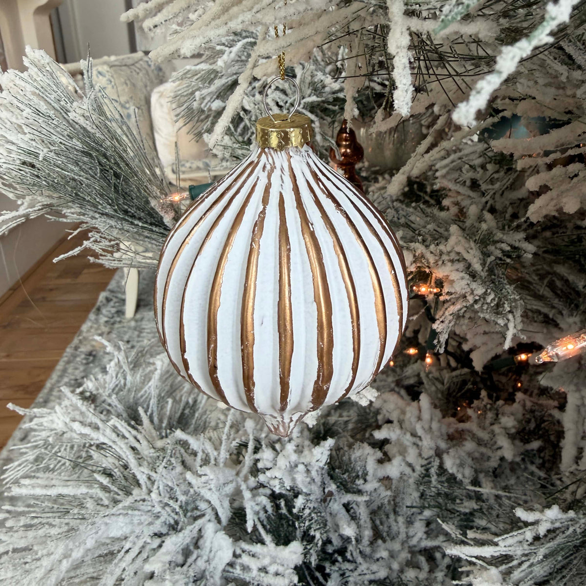 Decorative striped ornament on a frosted Christmas tree