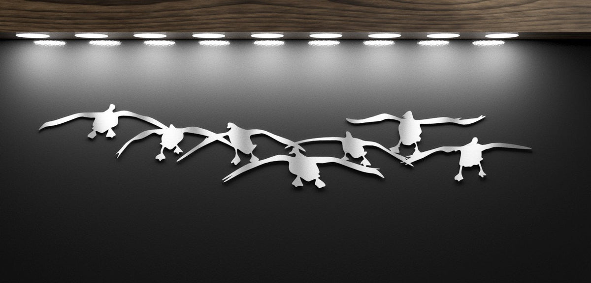 Metallic bird sculptures on a dark background with lights above