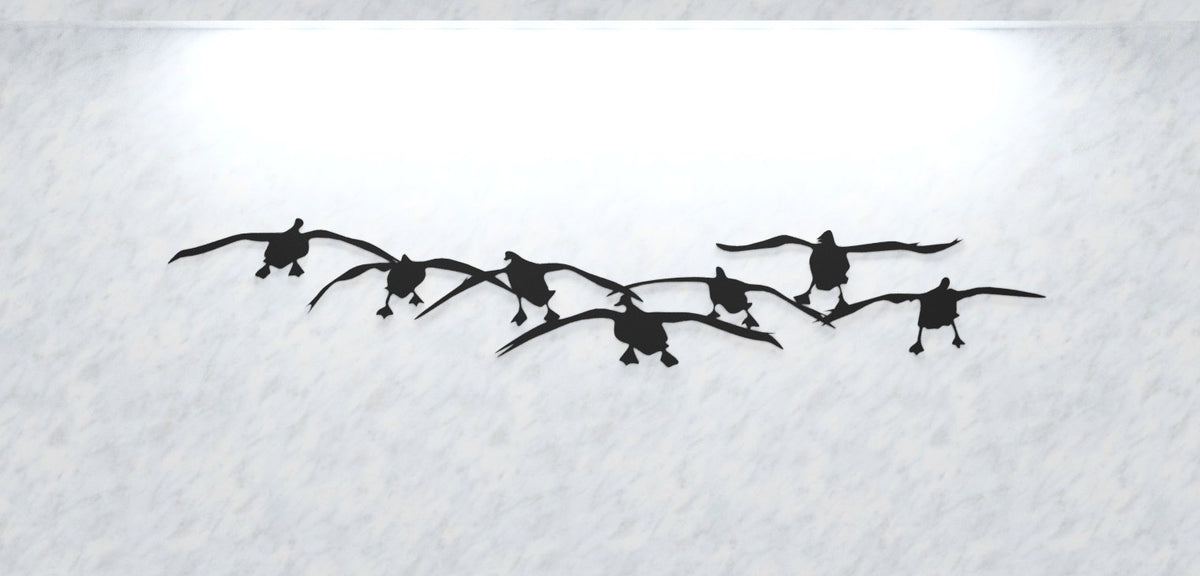 Silhouette of a group of birds flying against a white background