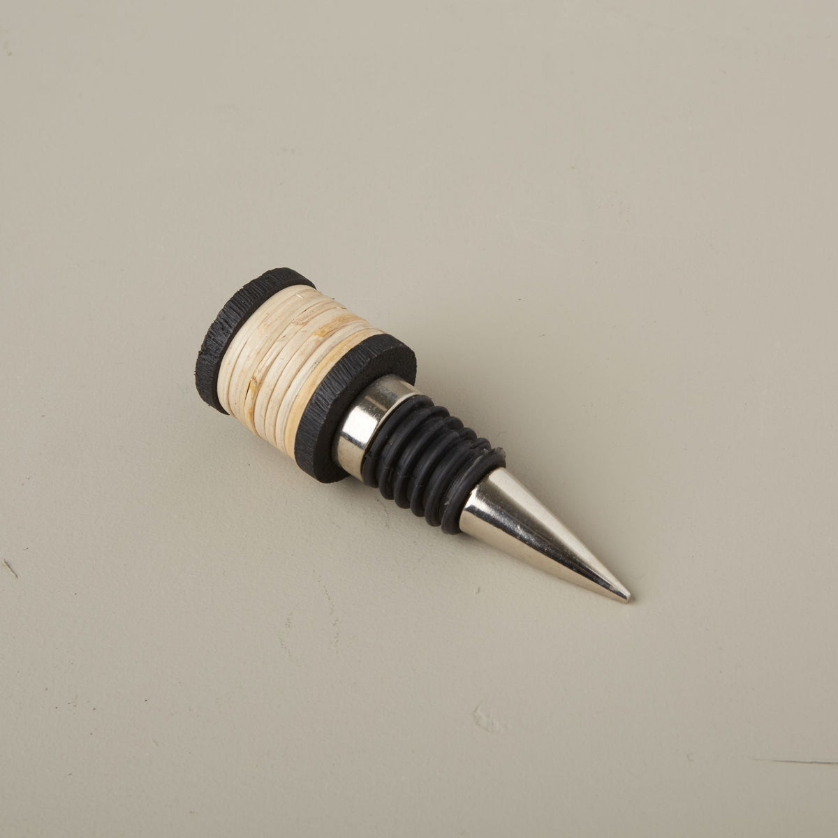 Wine bottle stopper with wooden and black design on a beige background