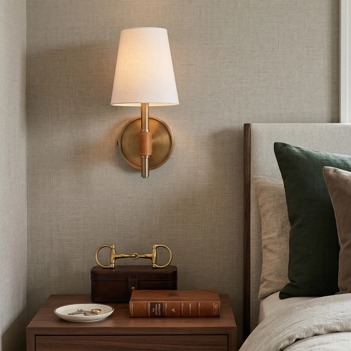 Wall-mounted lamp on a textured wall above a wooden nightstand with decorative items.