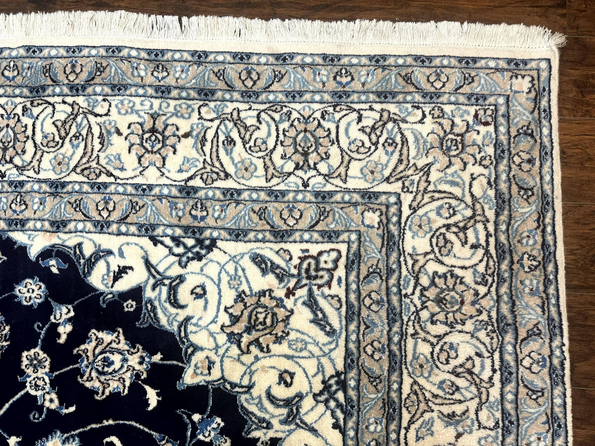 Close-up of a patterned rug with intricate designs on a wooden floor.