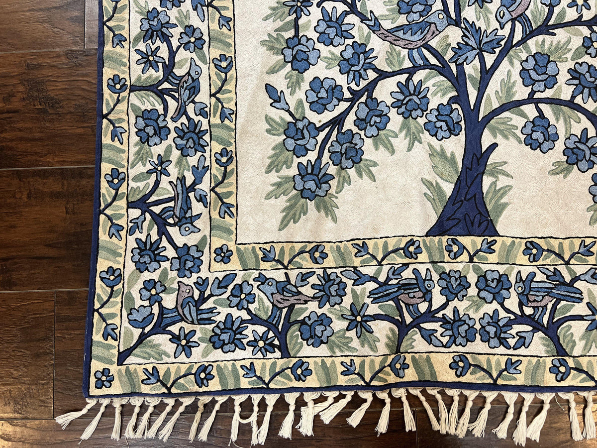 Decorative tablecloth with floral and bird pattern on a wooden surface
