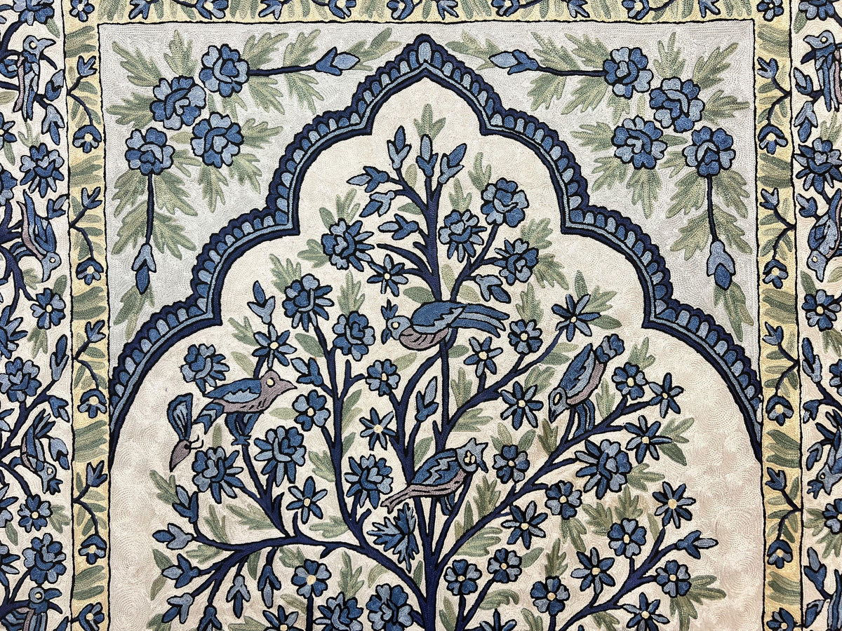 Decorative rug with floral and bird pattern on a wooden floor