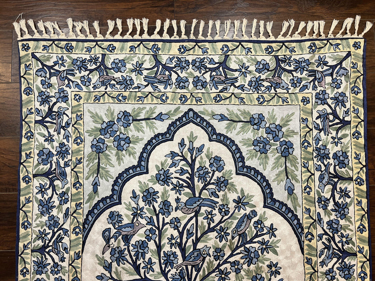 Decorative rug with floral and bird pattern on a wooden floor
