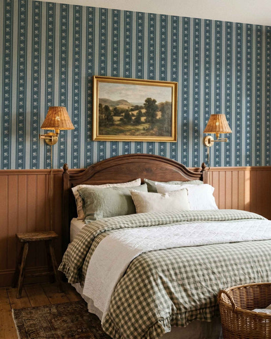 Bedroom with wooden headboard, checkered bedding, and striped wallpaper.